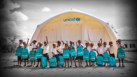 Happy children in front of a UNICEF tent