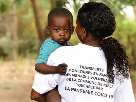 In October 2020, an agent holds a boy while registering vulnerable families in Moro, a suburb of Kinshasa, Democratic Republic of Congo. 