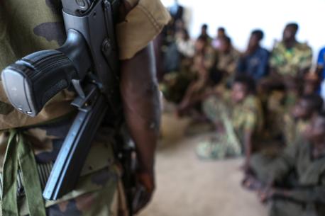 An armed soldier looks on near a group of 21 children, aged 14-17, who were released from armed groups following a series of meetings between UNICEF and the President of Central African Republic Michel Djotodia. © UNICEF/NYHQ2013-0242/JORDI MATAS