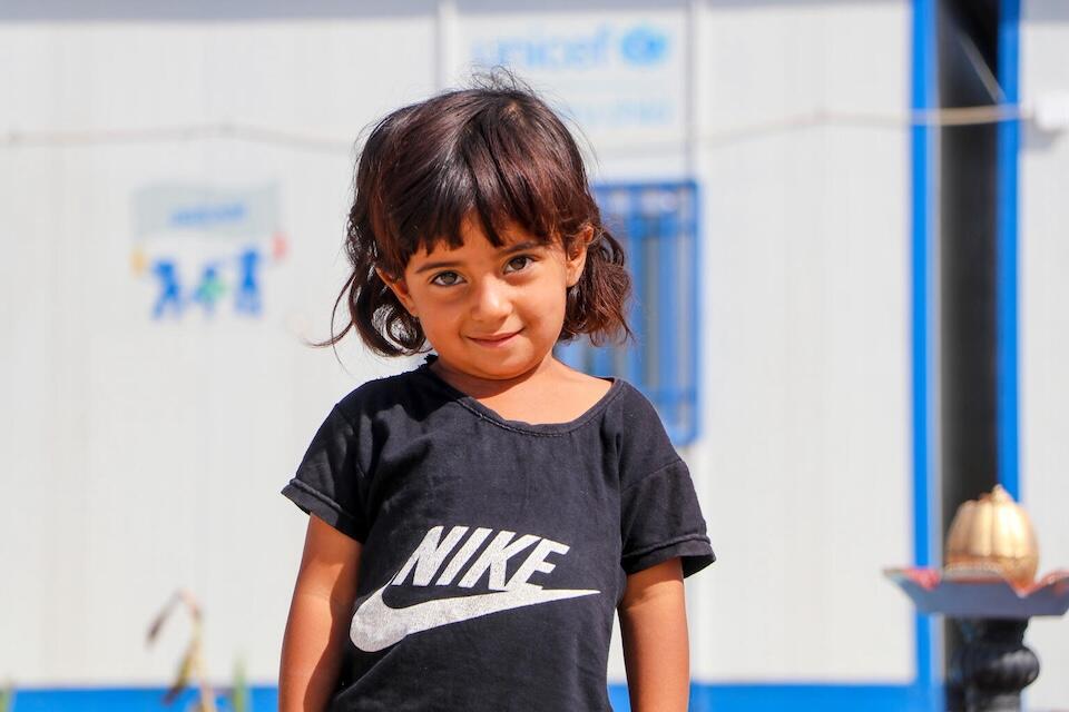 Sahar, 3, stands outside the UNICEF -supported early childhood education center called 'Dream' in Ain Khadra camp in Al-Malikiyeh, Al-Hasakeh, Syria, on Sept. 21,  2023.