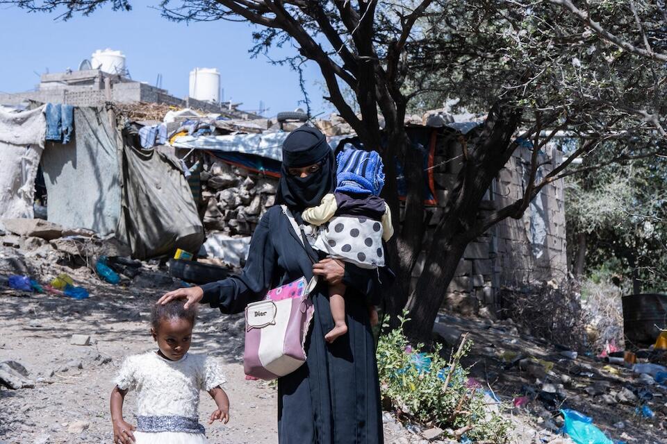 Yousra, 16, walks to school with two of her daughters in Taizz, Yemen.