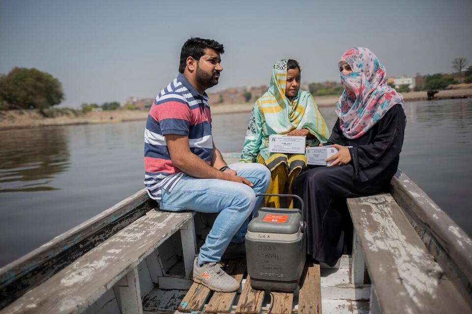 On April 14, 2023 in Lahore, Punjab province, Pakistan, two vaccinators and a social mobilizer travel by boat to conduct an integrated outreach activity to vaccinate children in an urban slum where the population lacks access to a nearby health facility.